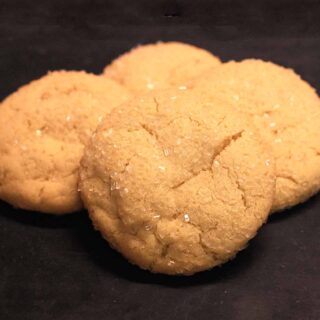 Four chewy sugar cookies on a cutting board