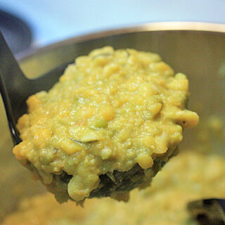 A ladle filled with Rosemary Split Pea Soup