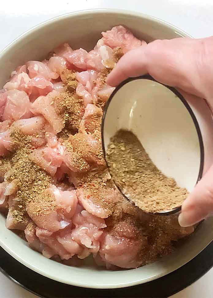 Seasoning the chicken strips.