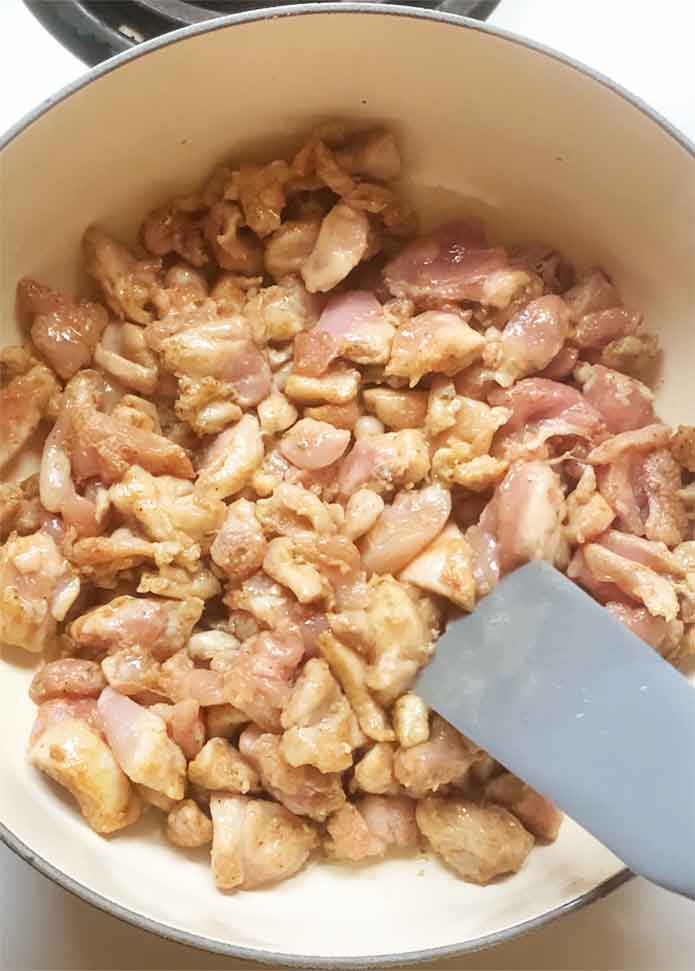 Searing the chicken in the pot.