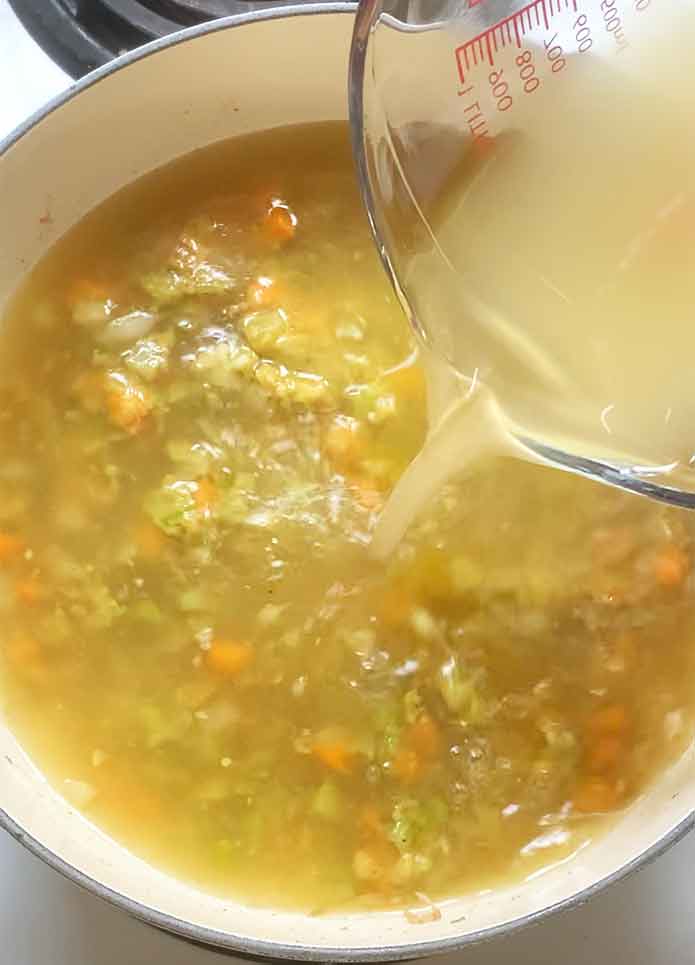 Pouring in the chicken broth.