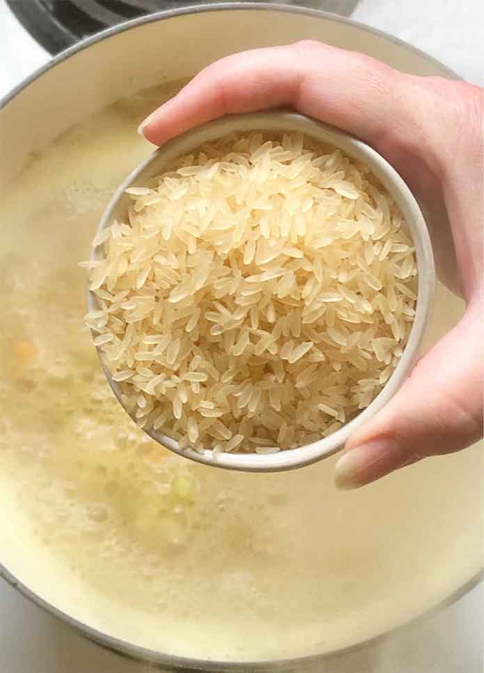 Adding the rice to the pot.