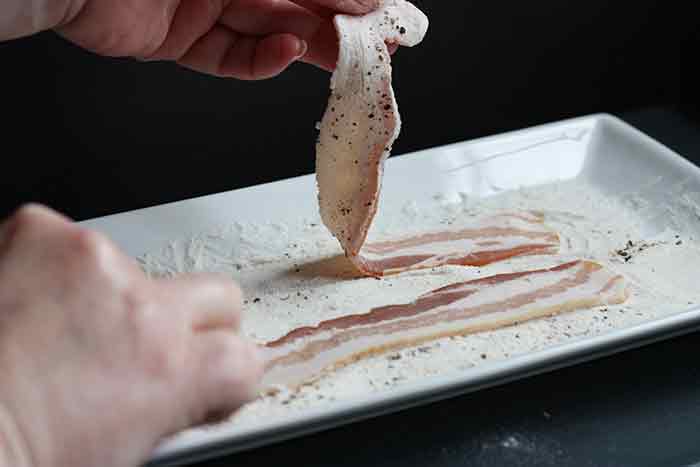 Dredging bacon strips through flour