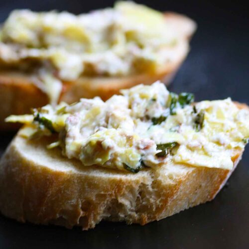 Two crostinis with Baked Artichoke Olive Dip