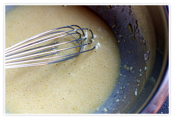 Whisking the egg mixture that will thicken the soup.