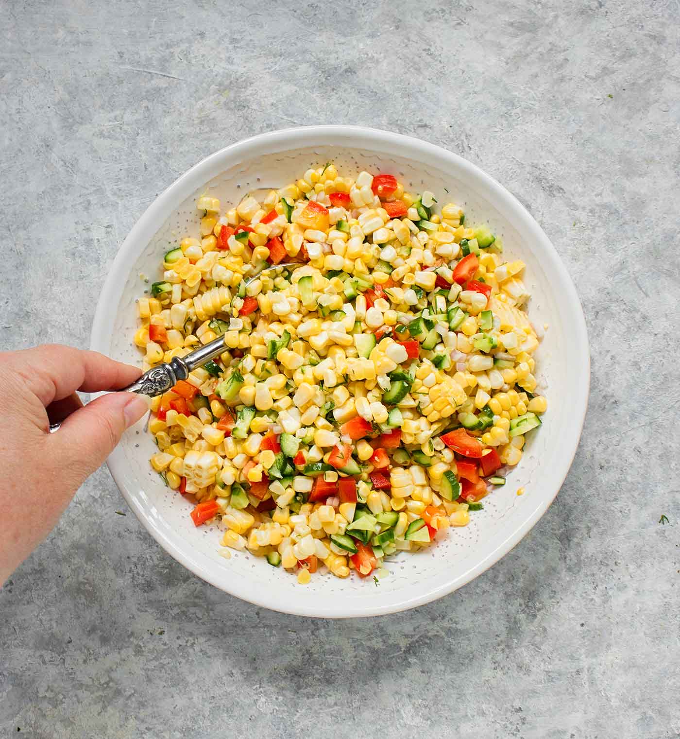 Tossing the corn salad with the dressing.