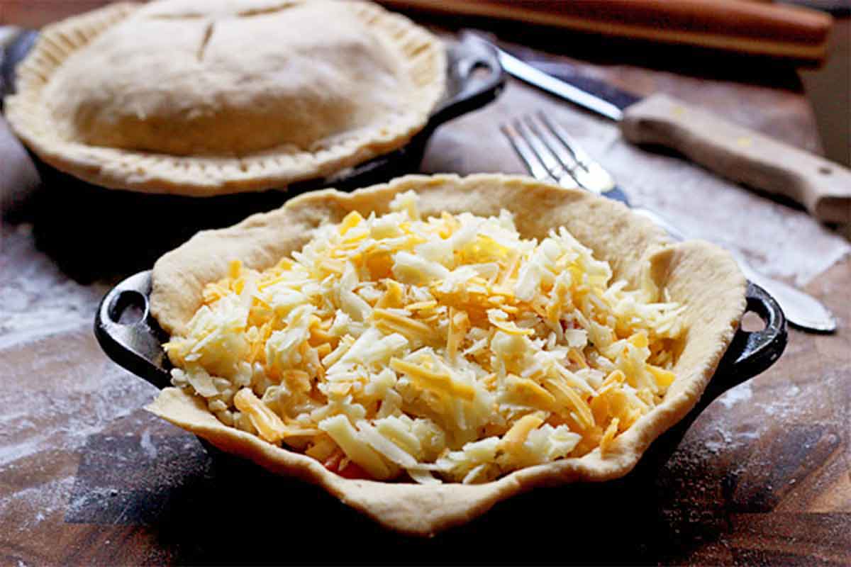 One single-serve tomato corn pie in a cast iron dish.