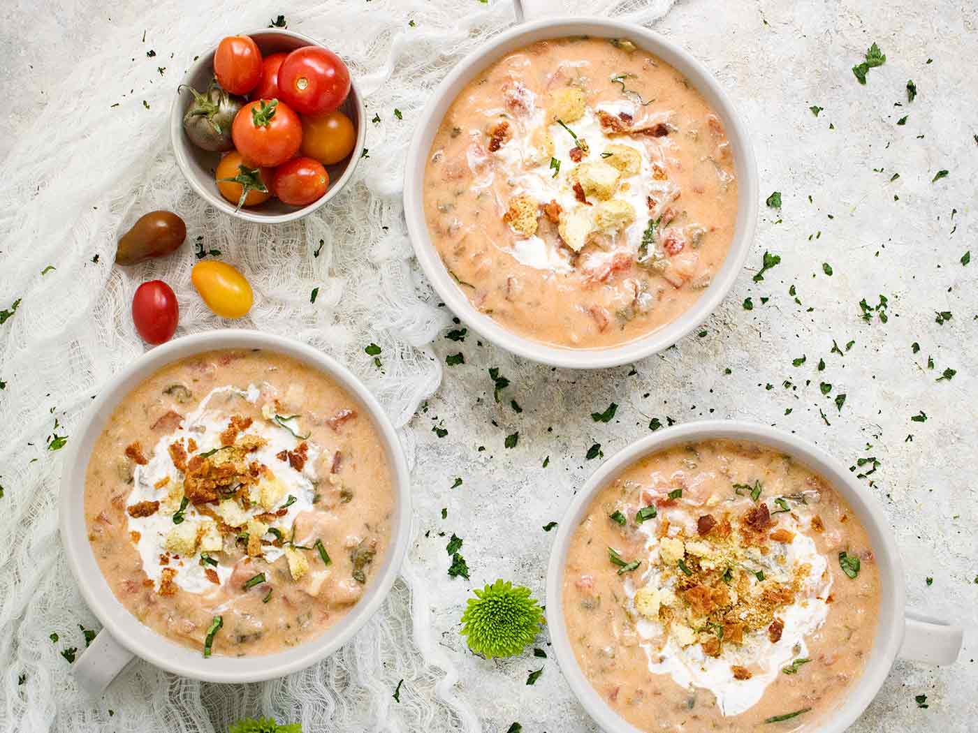 Three mugs of BLT Soup, swirled with creme fraiche and topped with crushed croutons