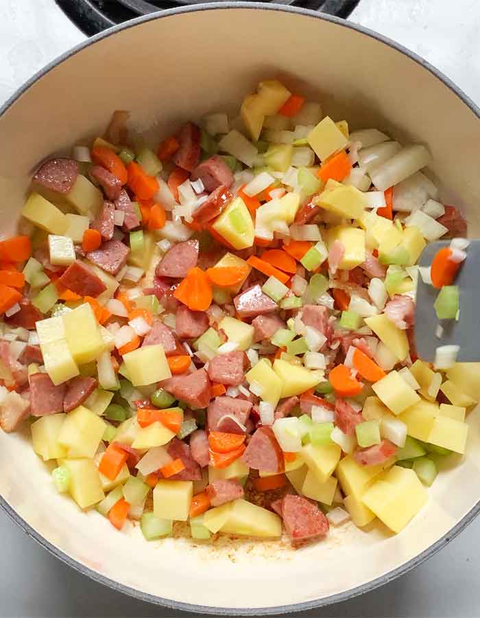 Aromatic vegetables and potatoes in the pot.