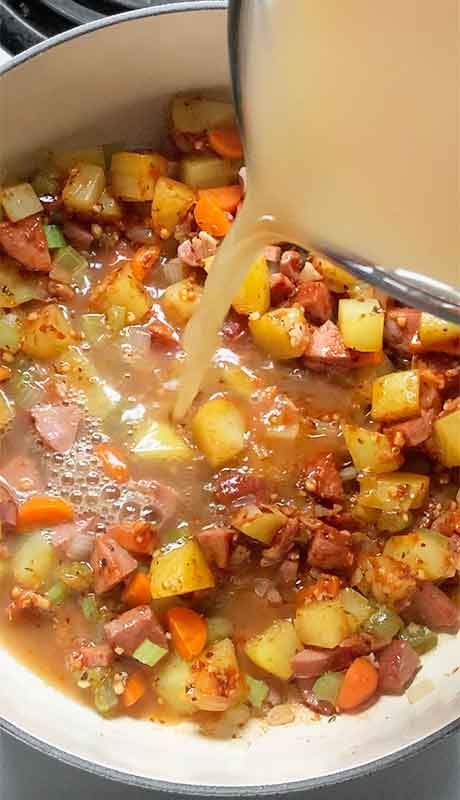 Pouring in the chicken broth.
