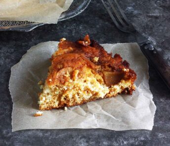 A slice of Salted Caramel Apple Skillet Cake on a square of parchment paper.