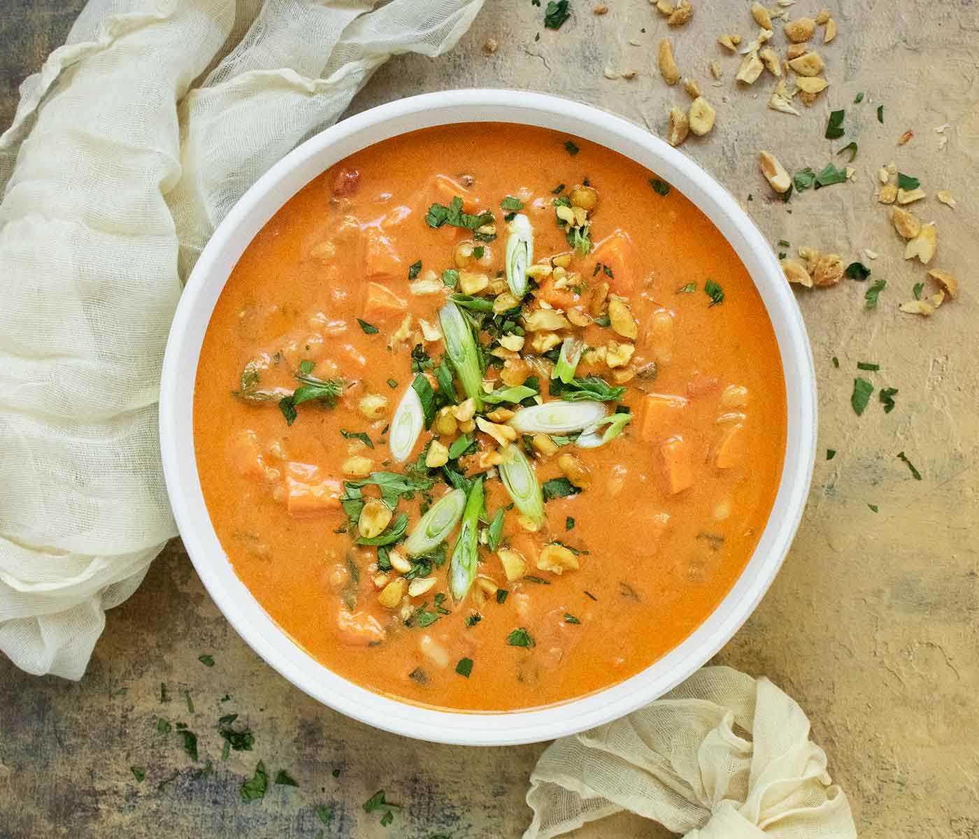 A bowl of West African Peanut Soup with toppings.