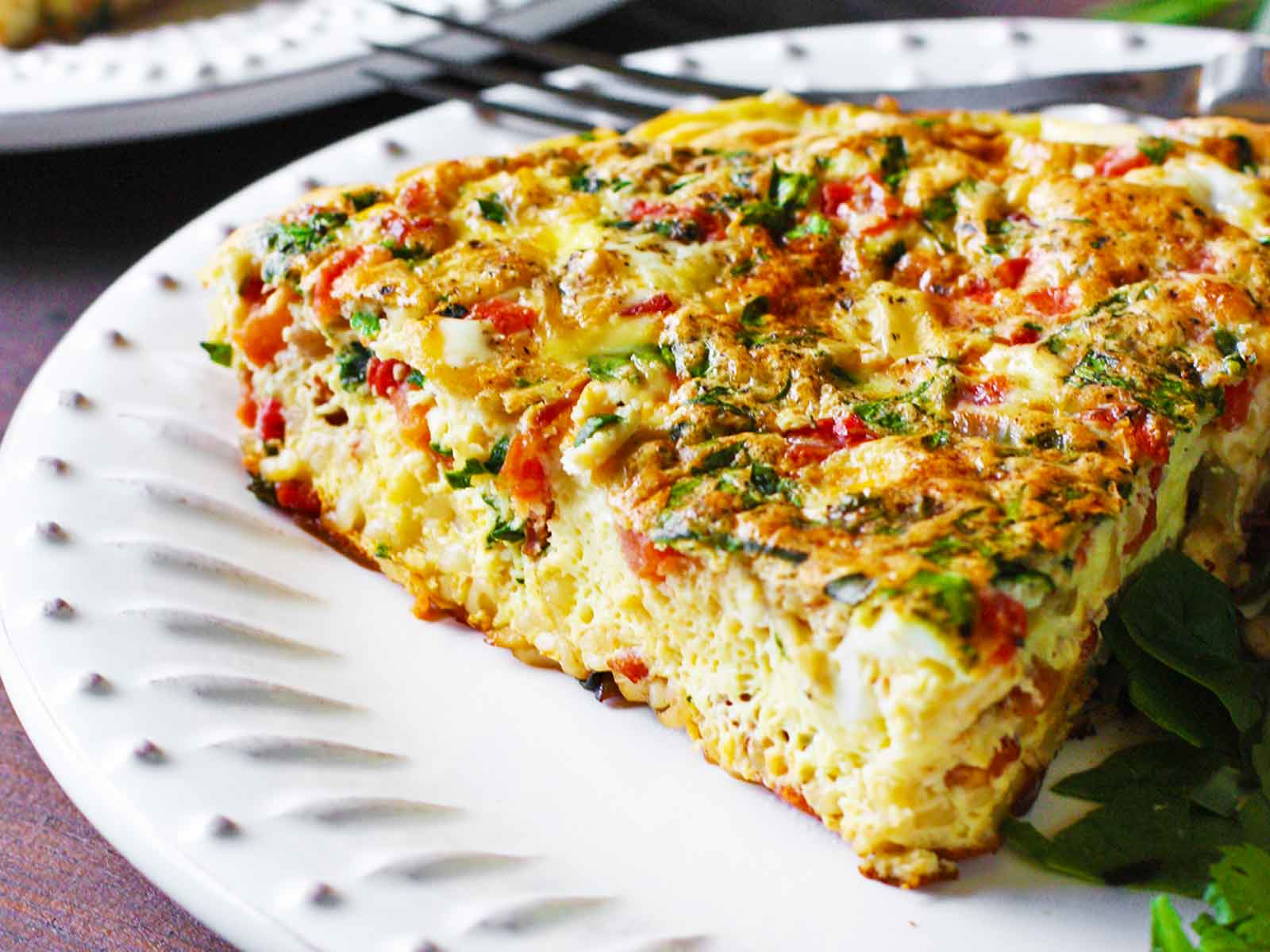 A slice of BLT Frittata with Ramen Noodles on a white plate.