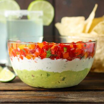 Triple Layer Guacamole Dip in a glass bowl.