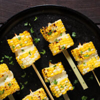 Grilled Corn Kebabs with Salty Cheese - Sweet and crunchy disks of fresh corn sandwich salty, grillable Greek cheese. A great summer party appetizer or side!