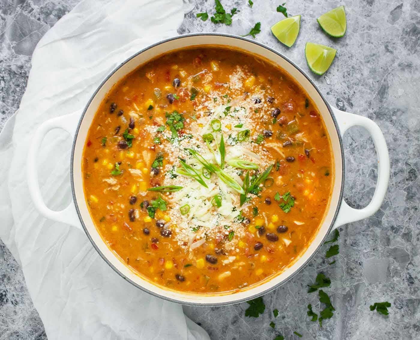 Overhead photo of Chicken Enchilada Soup in a large white Dutch oven.