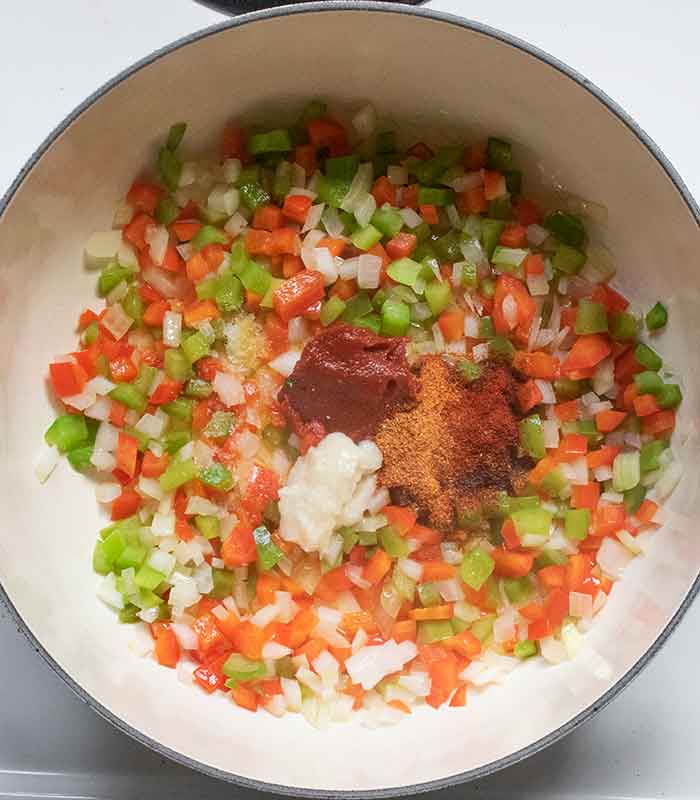 Adding the seasonings and spices to the vegetables.