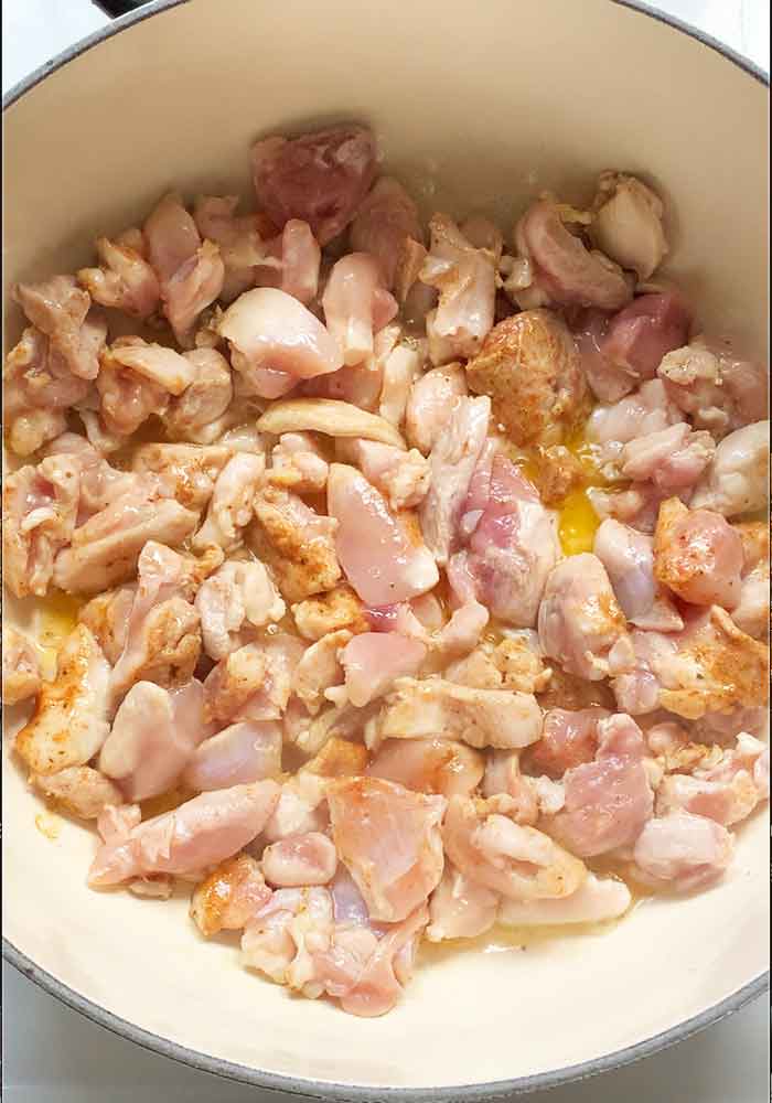 Chicken thigh pieces cooking in the pot.