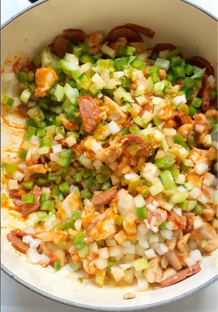 Adding the Holy Trinity aromatic vegetables to the pot.
