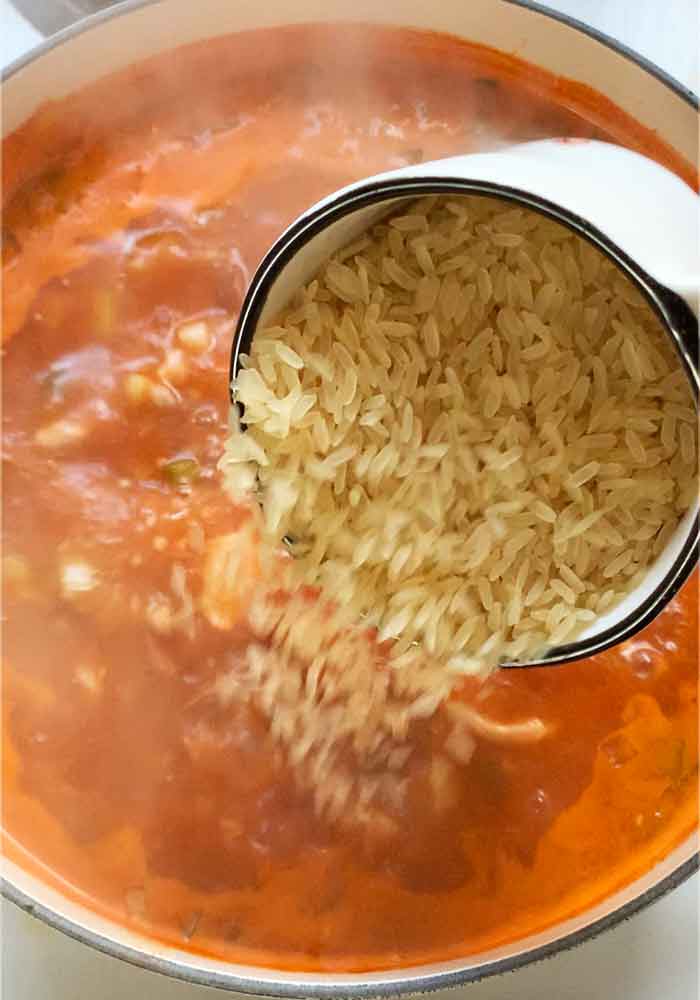 Adding the dried rice to the soup.