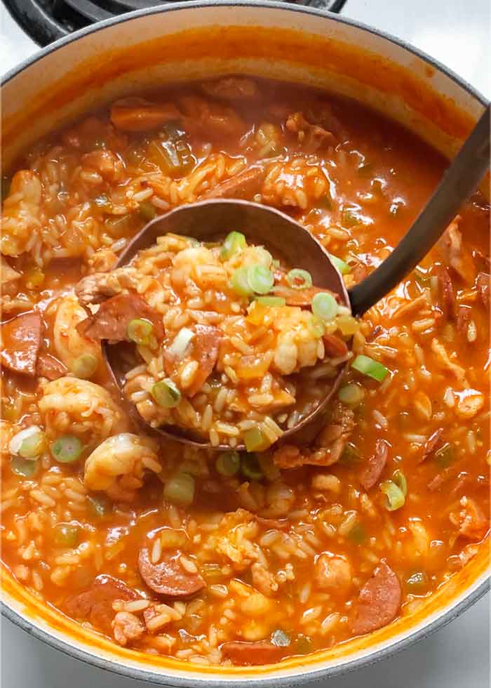 A copper and iron ladle in the soup pot.