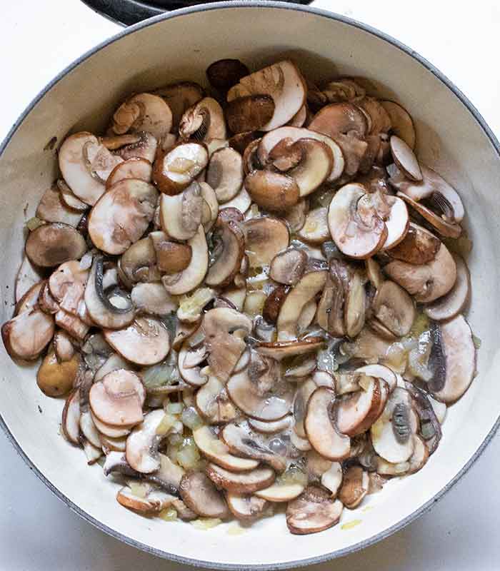 Sliced mushrooms sauteeing in the onion/butter mixture.