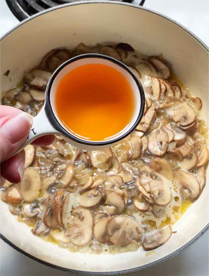 Adding sherry wine to the pot.