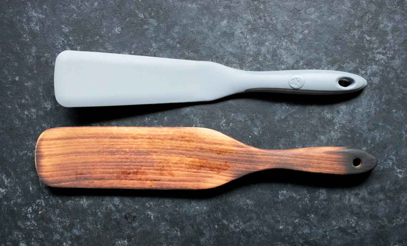Two spurtles, one gray silicone and one wooden.