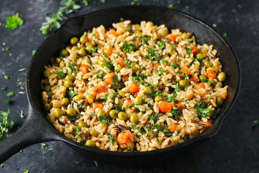 Rice Medley with Peas & Carrots in a cast iron skillet.