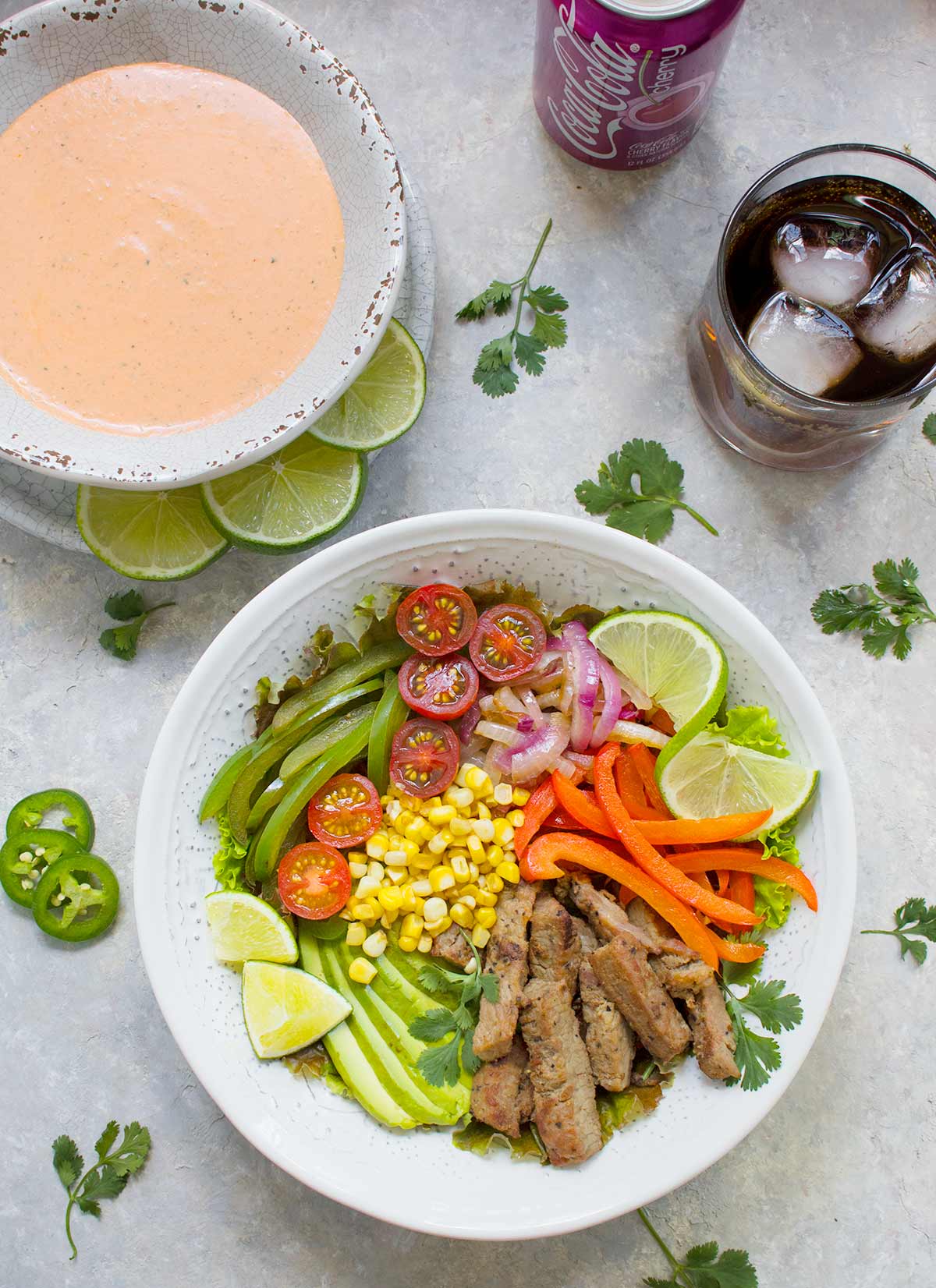 Beef Fajita Salad with Creamy Salsa Dressing, served in a bowl, with a glass of Cherry Coke.