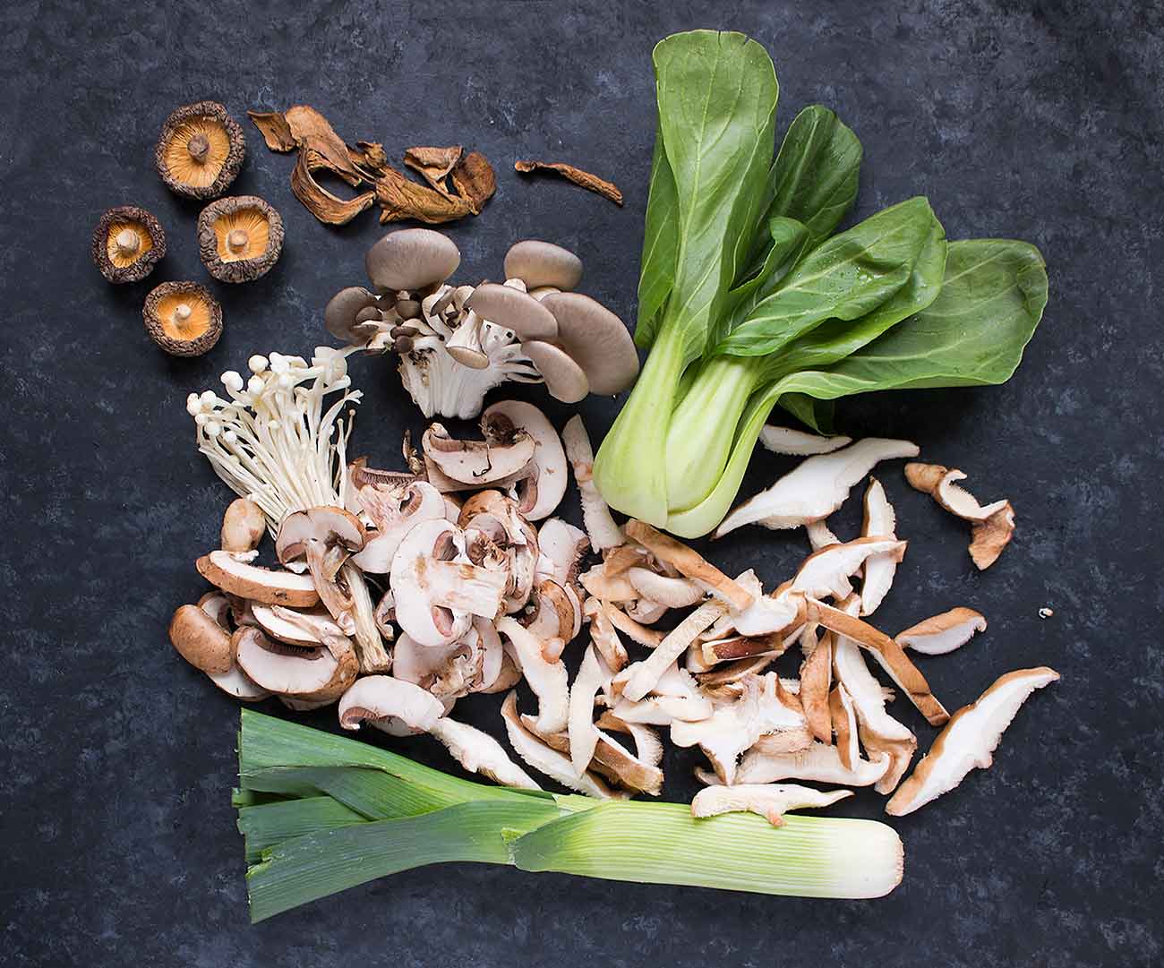 Fresh and dried mushrooms, plus baby bok choy and leek, for wild mushroom miso soup.