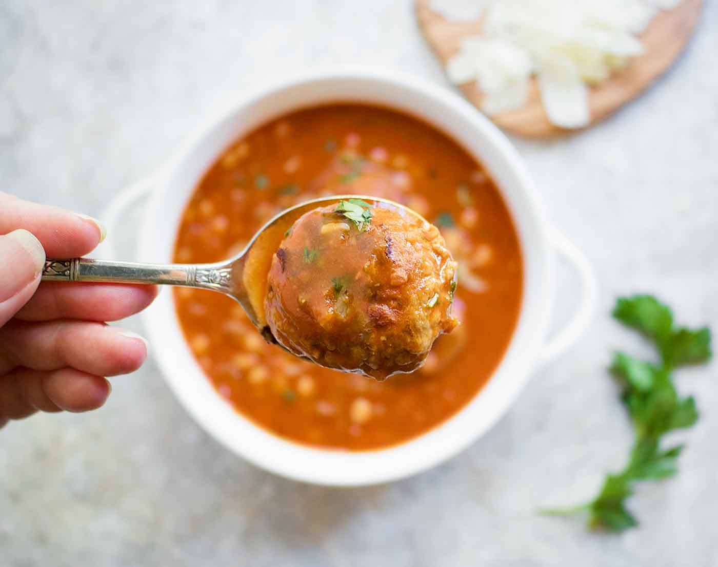 Close up of a Carando meatball from a bowl of Instant Pot Italian Meatball Soup