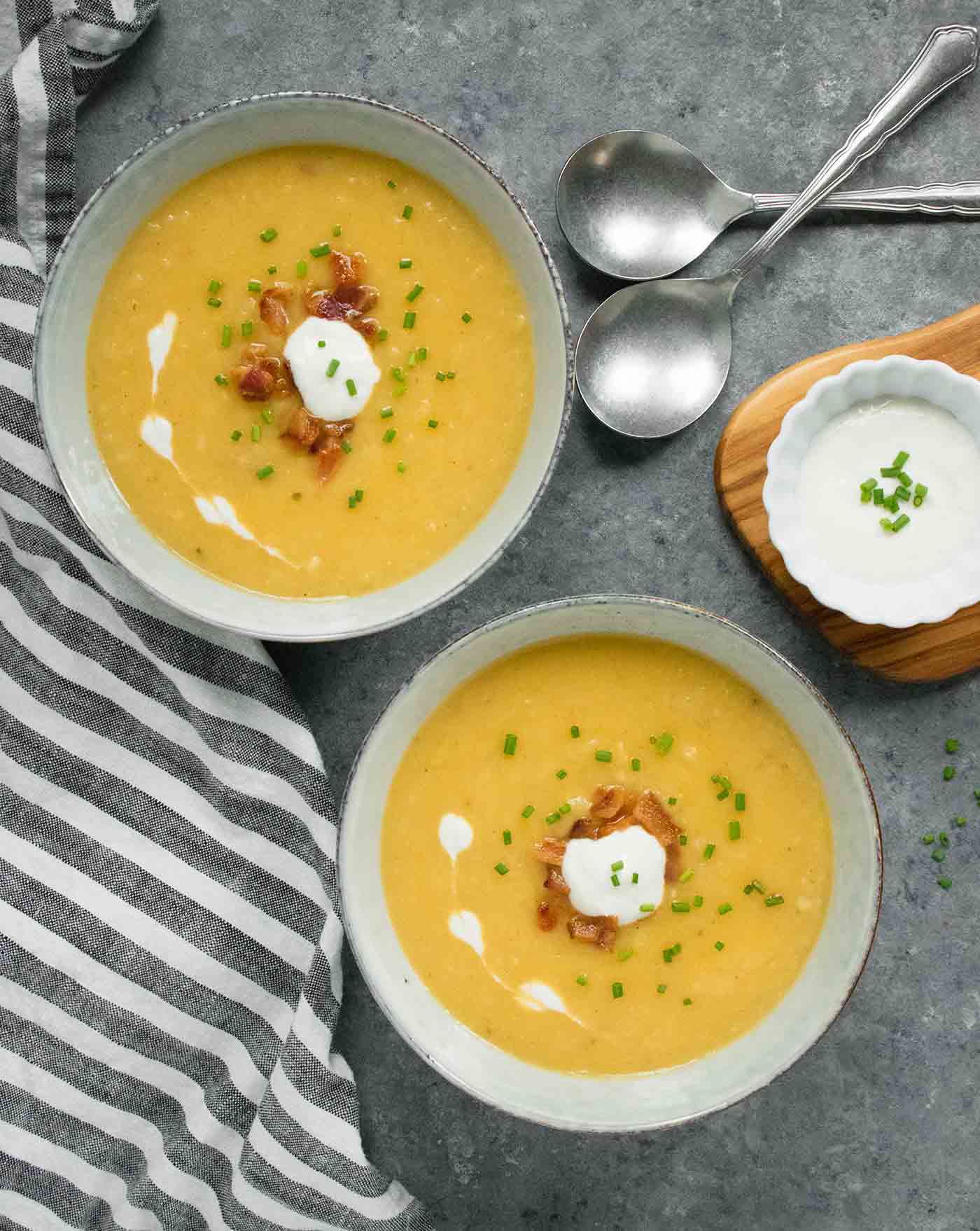 Two bowls of Instant Pot Potato Leek Soup and a bowl of horseradish sour cream on the side