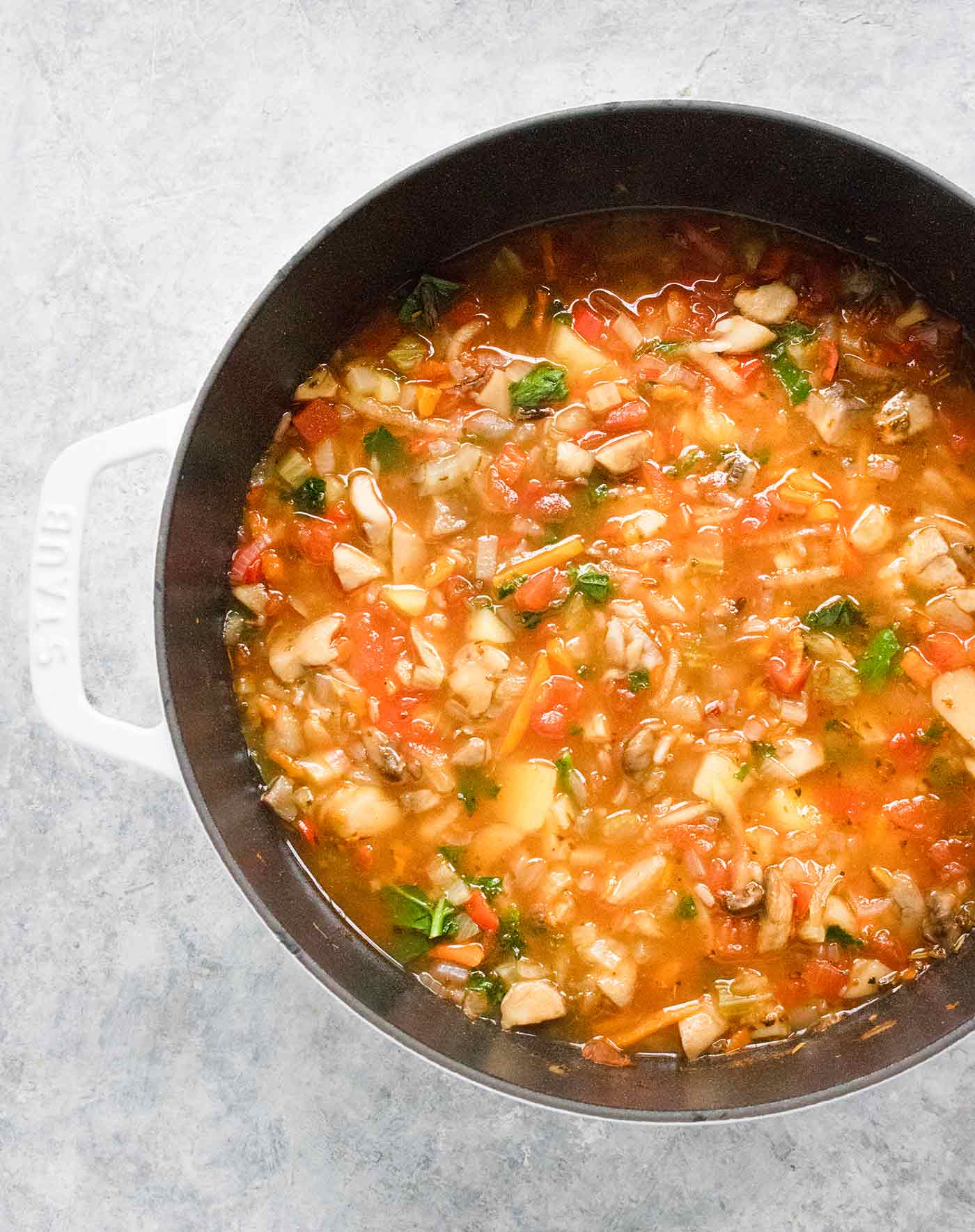 Hearty Vegetable Wild Rice Soup in a white Dutch oven