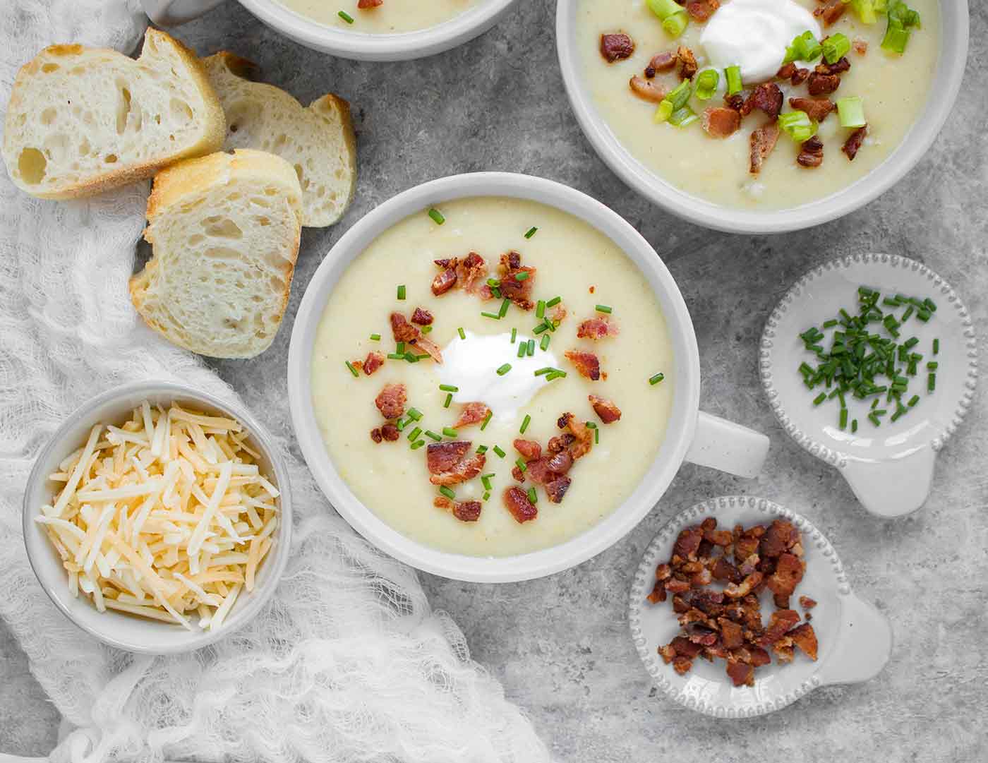 Bowl of Instant Pot Loaded Potato Soup with garnishes