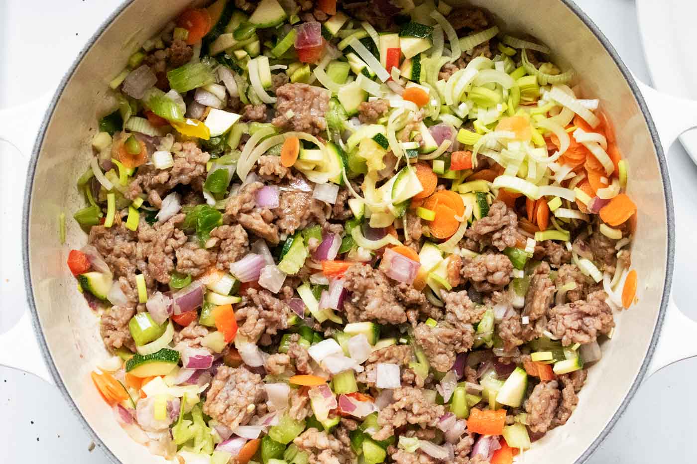 Chopped vegetables cooking in the sausage.