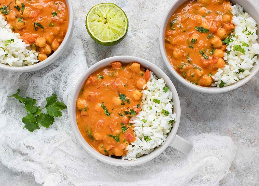 Three bowls of chickpea peanut stew with cauliflower rice blend