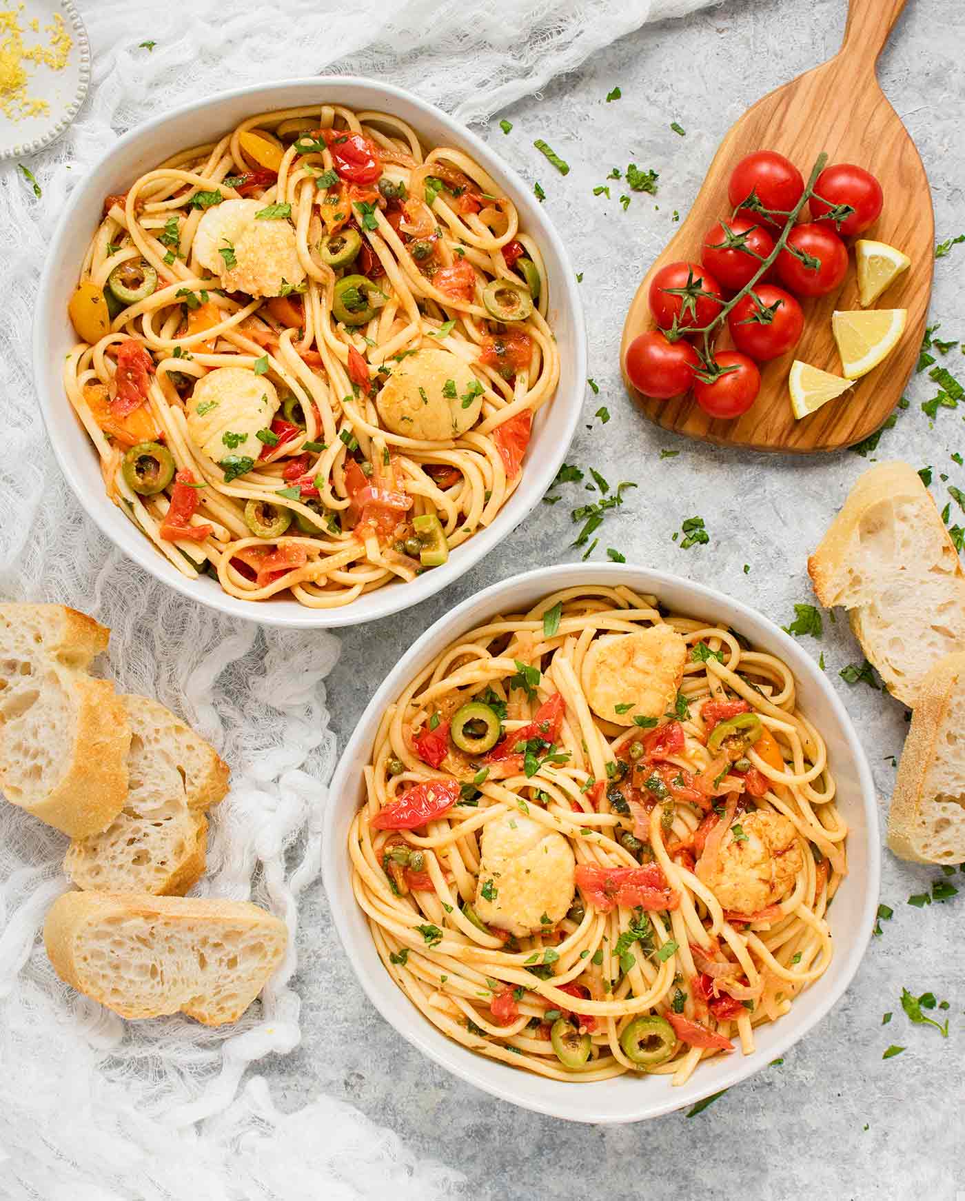 Two bowls of Mediterranean Scallop Linguine with bread on the side