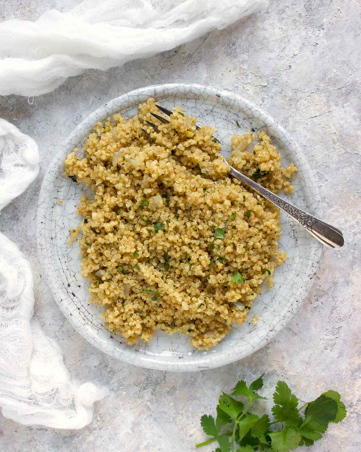 Perfectly cooked lemongrass quinoa on a plate with a fork, thanks to the Instant Pot.