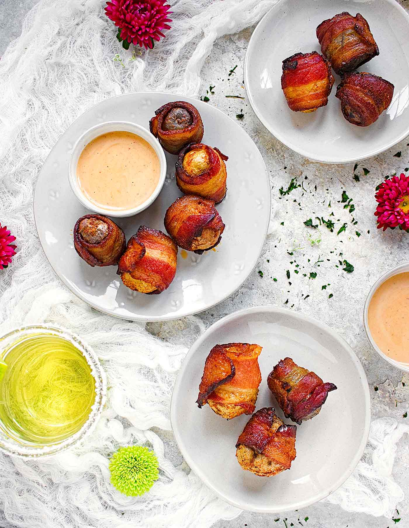 Bacon wrapped potatoes on individual plates with dipping sauce