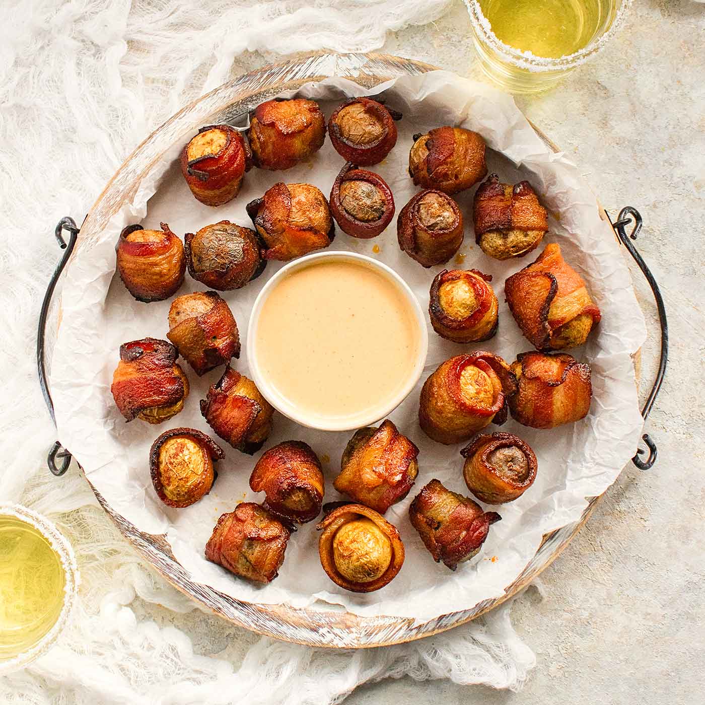 Bacon wrapped baby potatoes with BBQ ranch dipping sauce on a platter