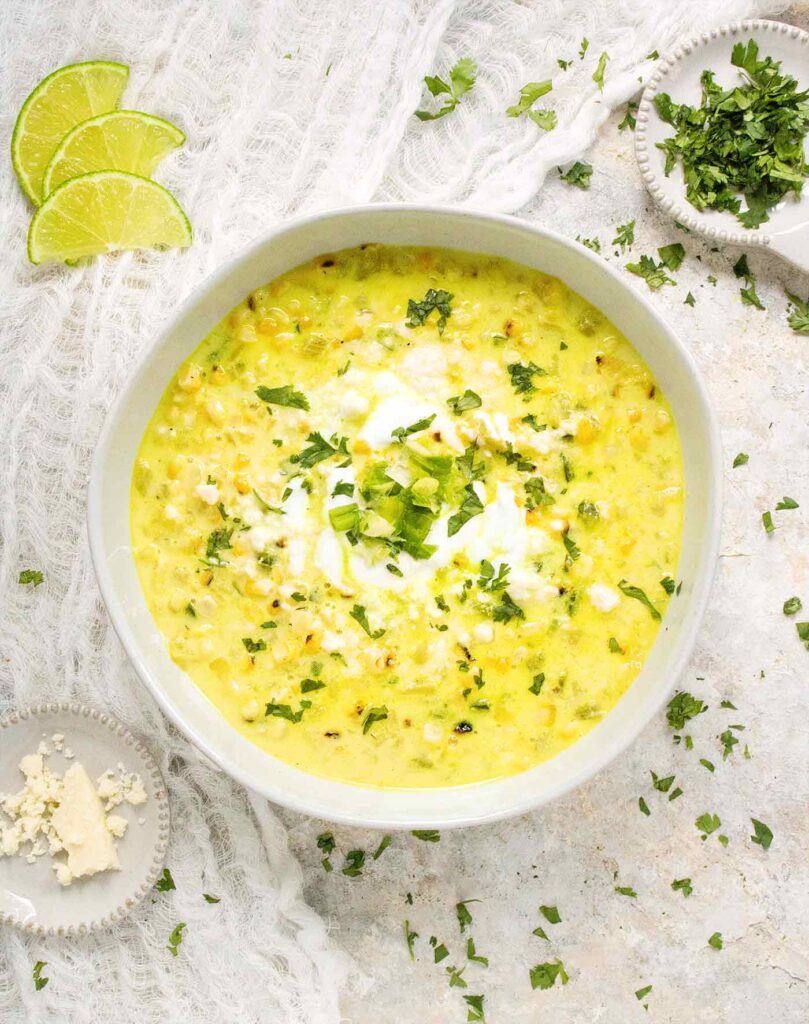 A bowl of corn soup on a white background