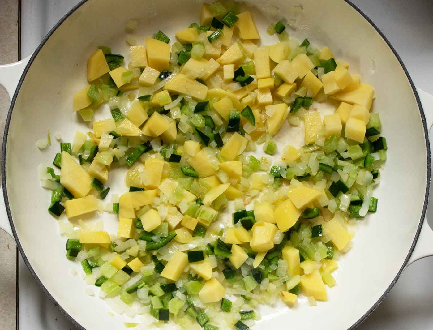 Onions, celery, poblanos, and potatoes cooking in the soup pot.
