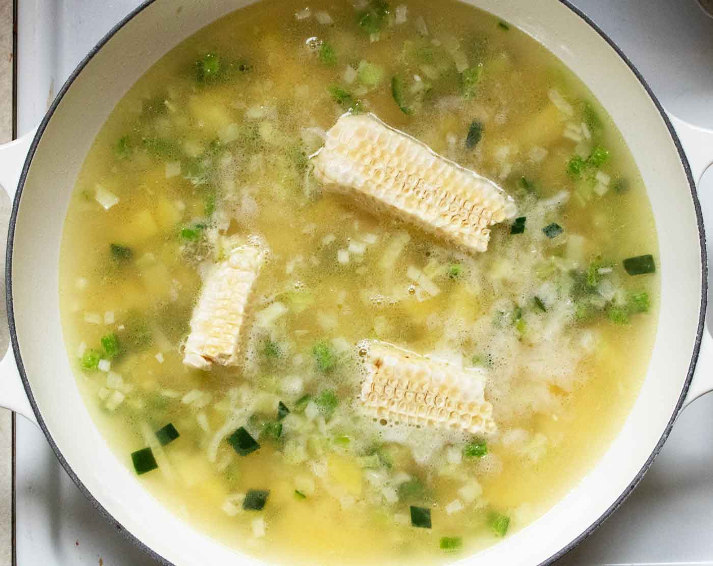 Cooking the corn cobs in the soup.