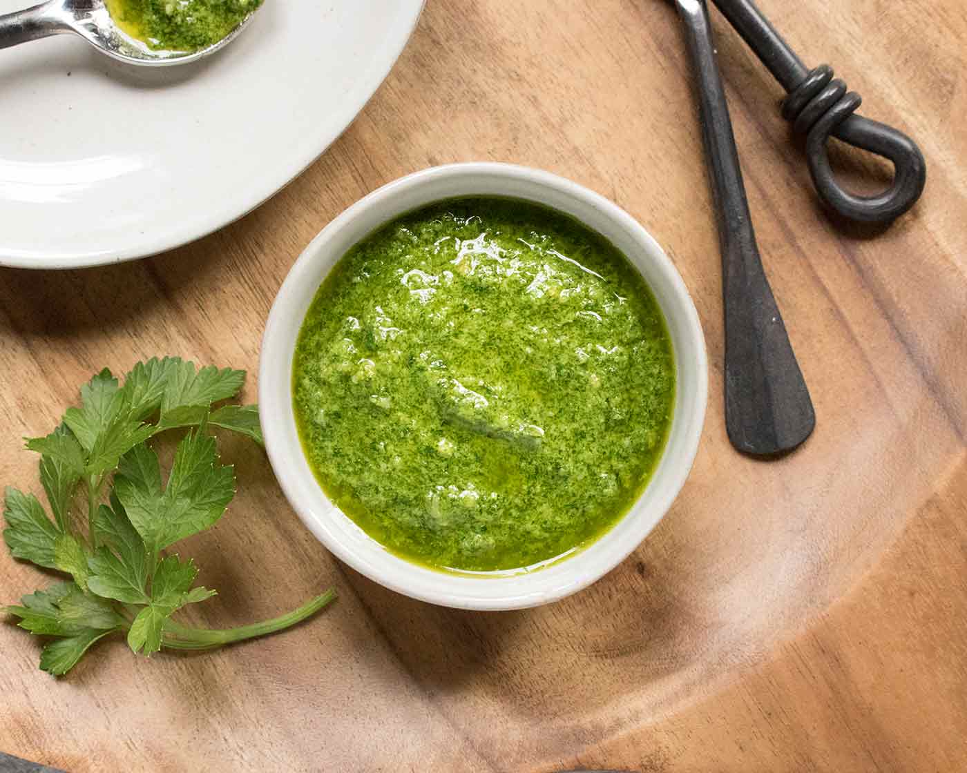 Homemade parsley pesto in a small bowl on a serving board