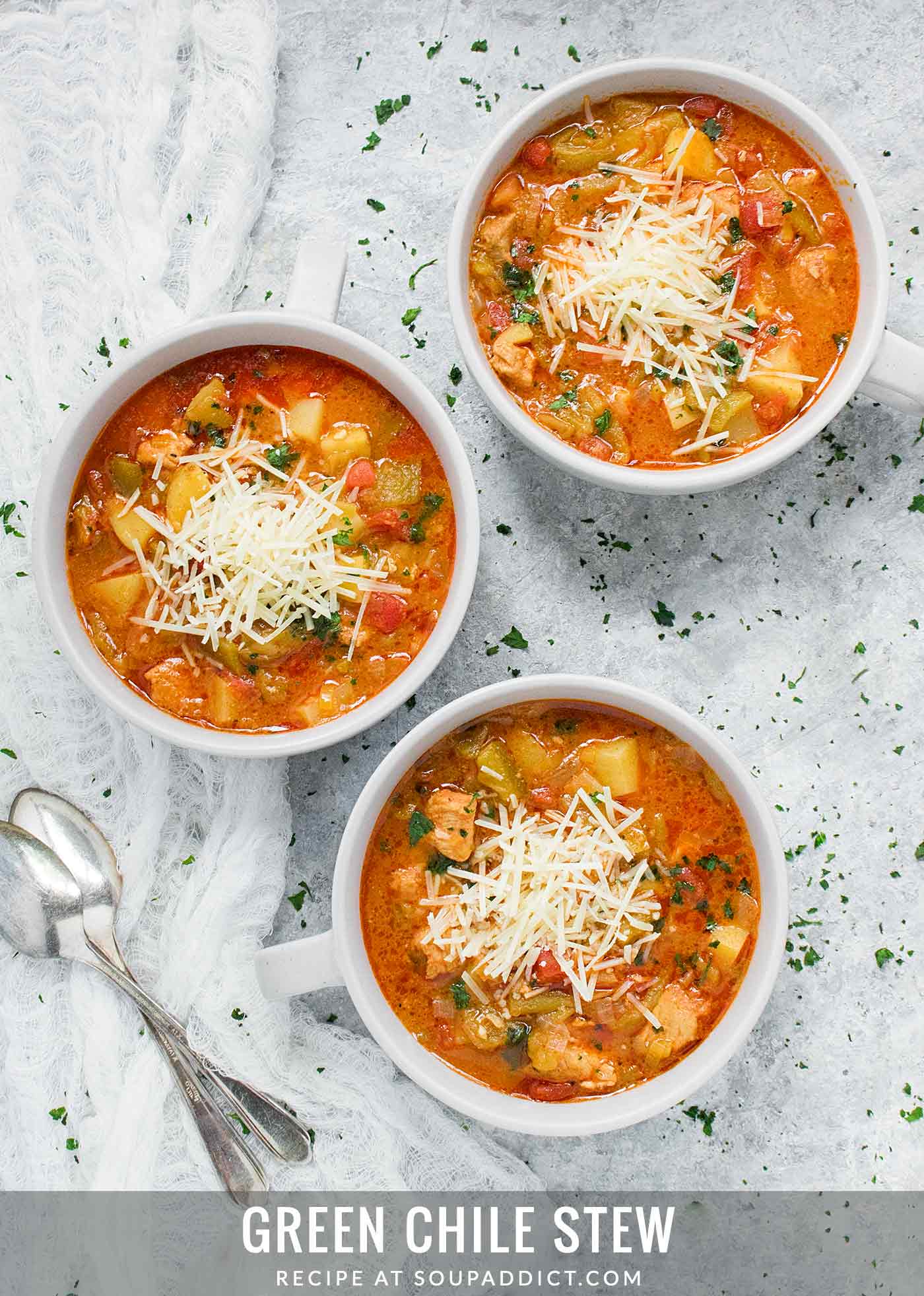 Three bowls of Green Chile Stew, each topped with aged cheese