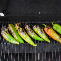 Hatch Chile roasting on a grill.