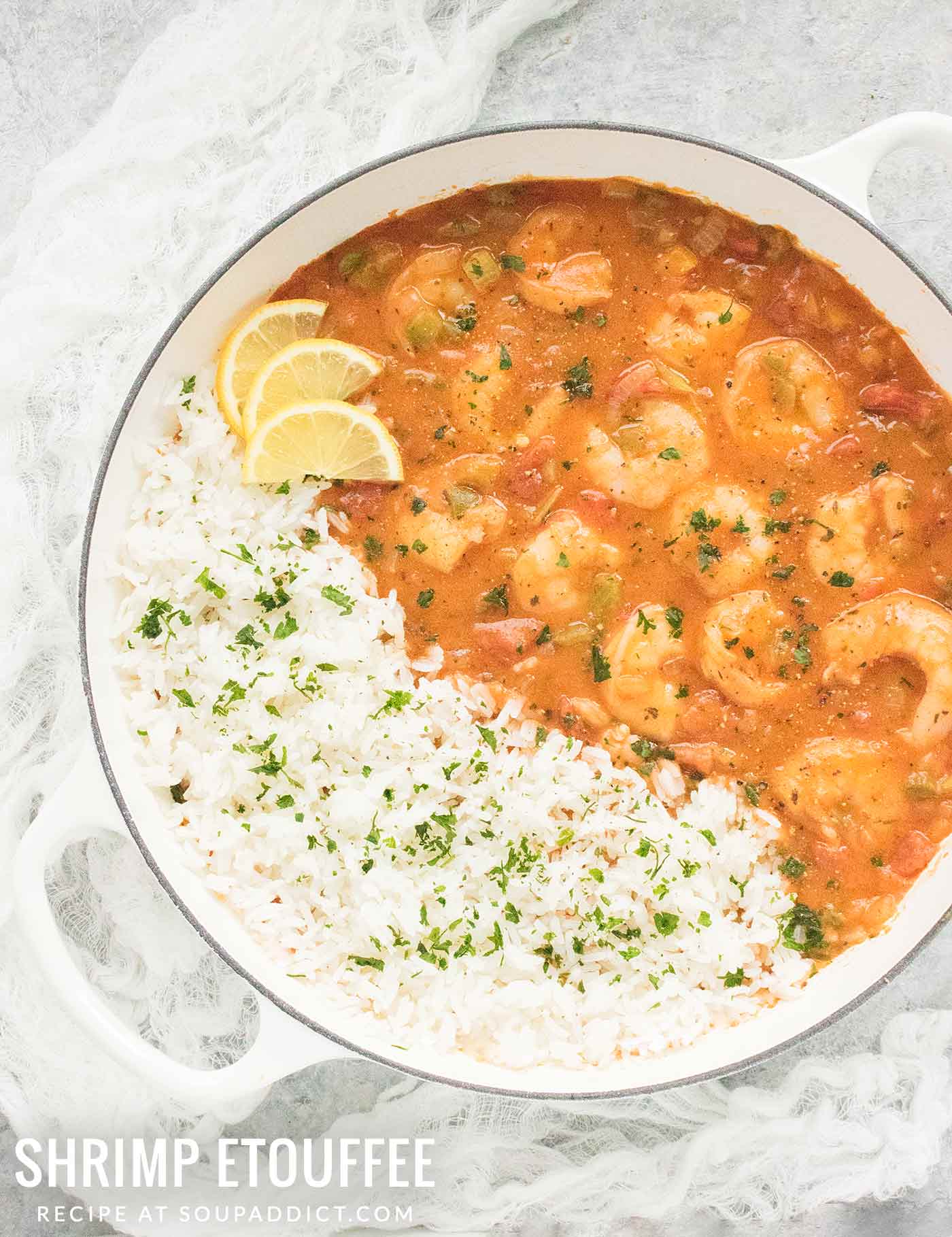 A white Dutch oven filled with saucy Shrimp Etouffee and herbed white rice