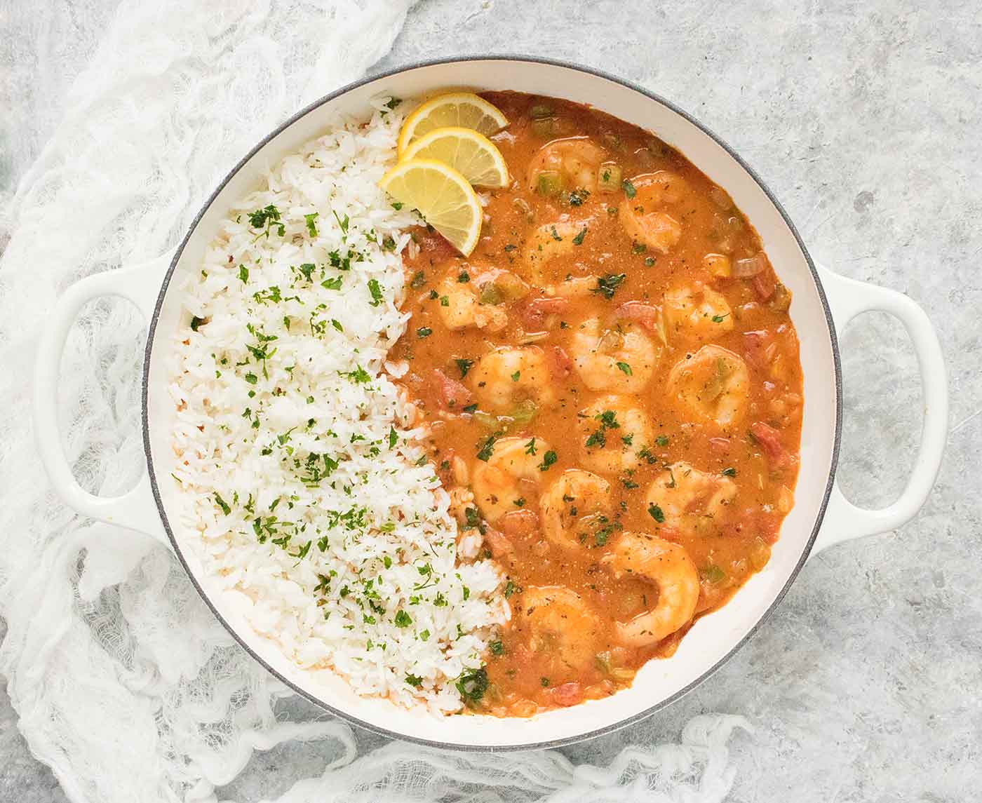 Shrimp Etoufee with white rice in a white Dutch oven.