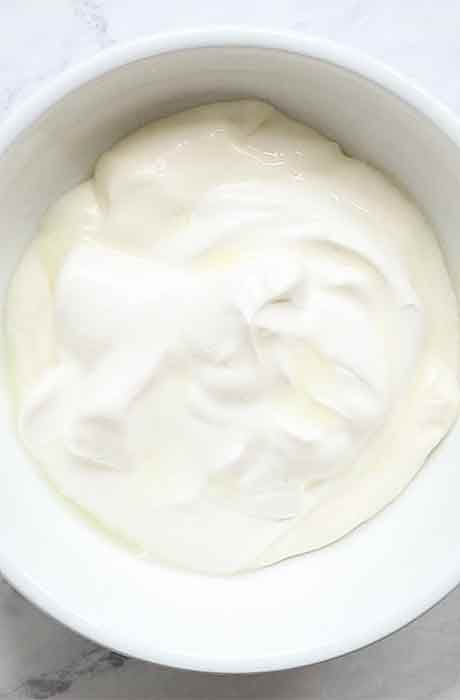 Mayo, sour cream, and lime juice in a white bowl.